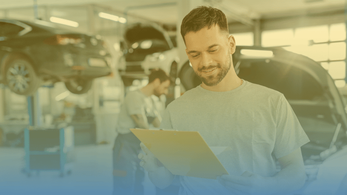 technician looking at clipboard in shop