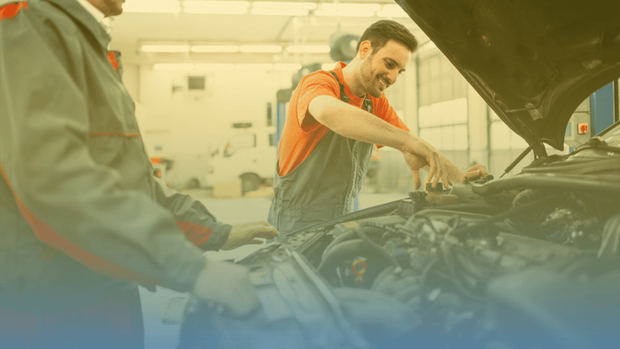 technicians working under the hood of a car