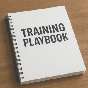 notebook that says training playbook on a wooden desk