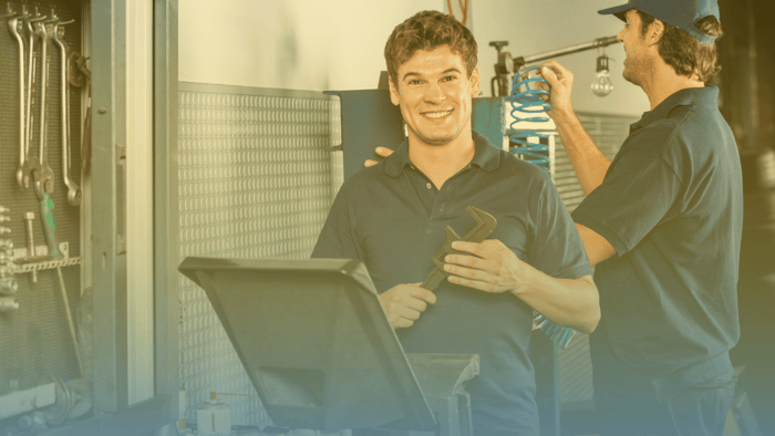 technician holding a wrench in a shop 