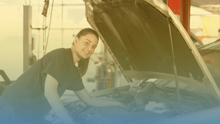 technician working under the hood of a car