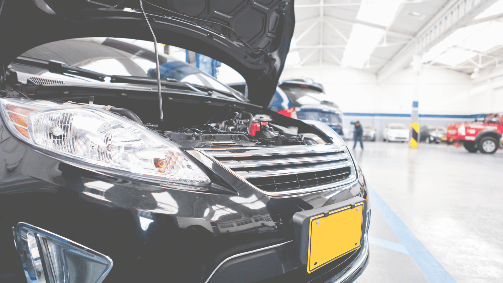 black car with an open hood in a shop bay
