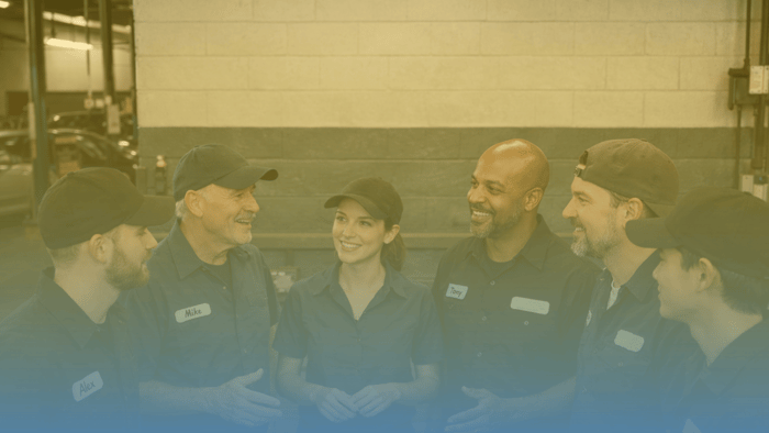 group of auto repair shop employees talking in a circle